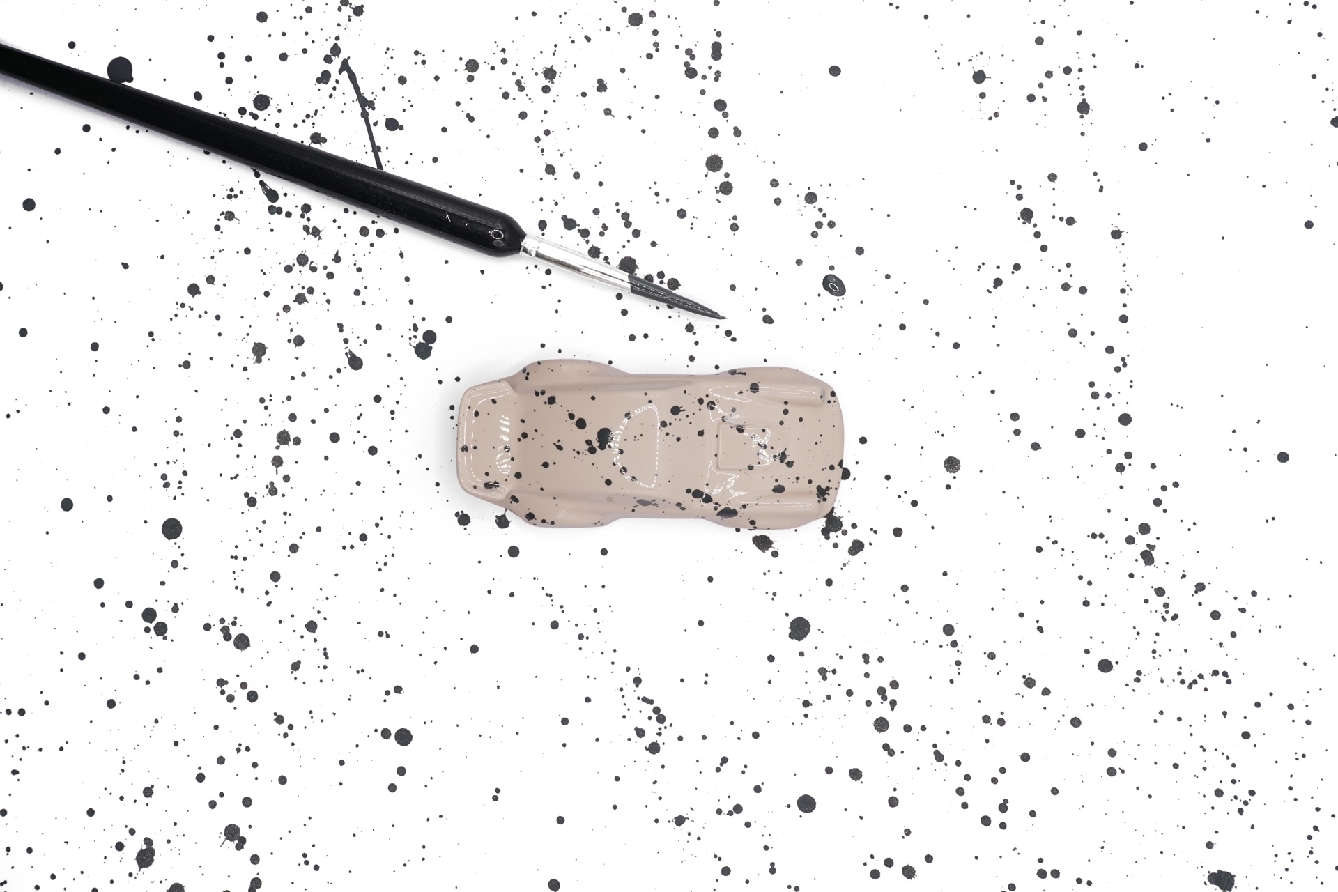 A miniature surrounded by ink splatters and the artist's brush